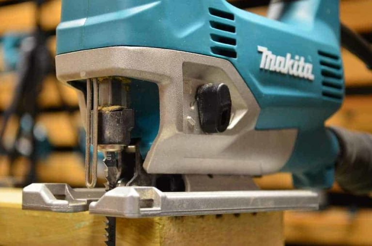 A close up of Makita JV0600 jigsaw on a top of a wooden plank