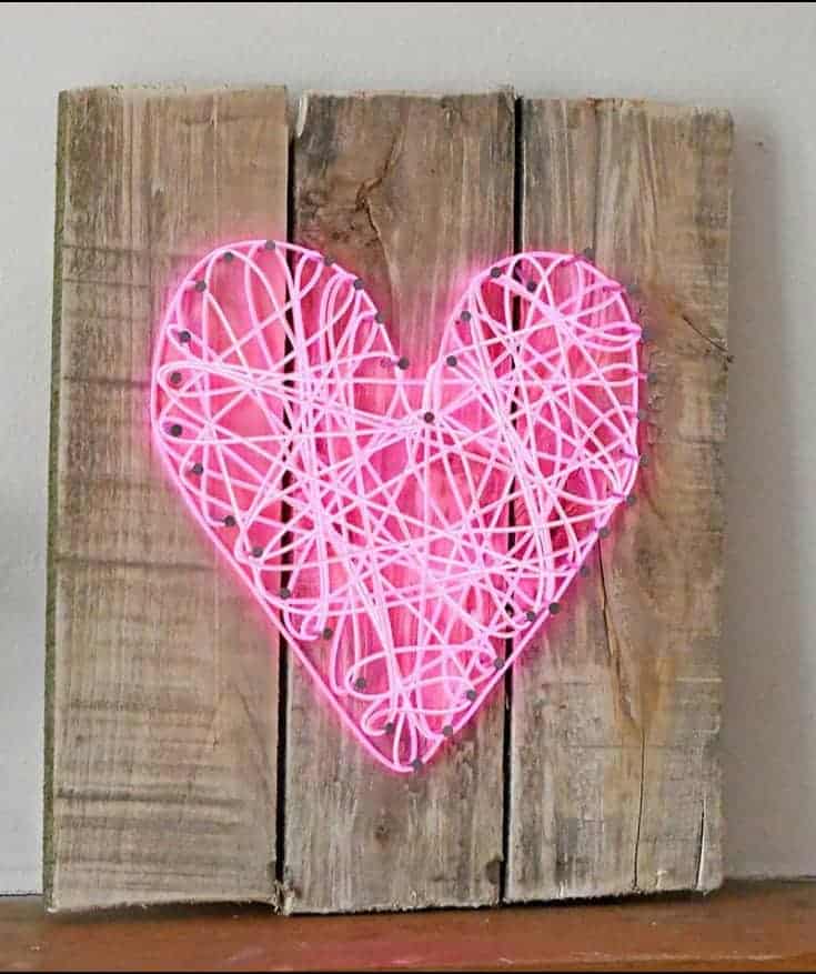 string art on a wooden background made with a neon string that lights up