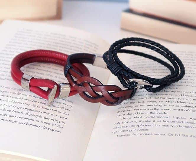 3 men leather bracelets for men on top of an open book