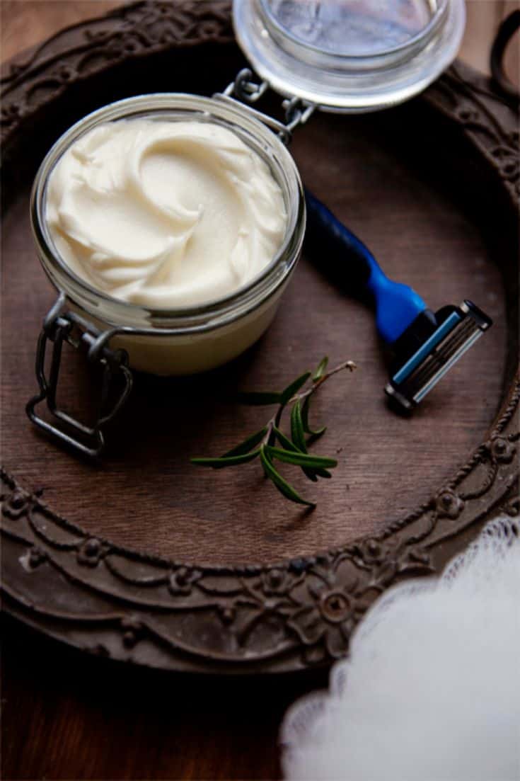 a jar with shaving cream next to a razor