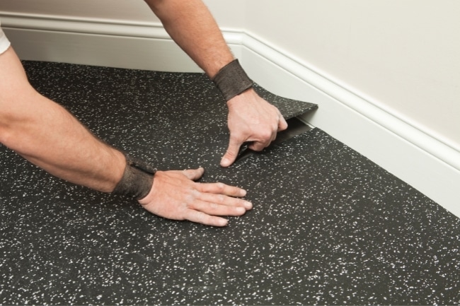 a man installing rubber floor tiles