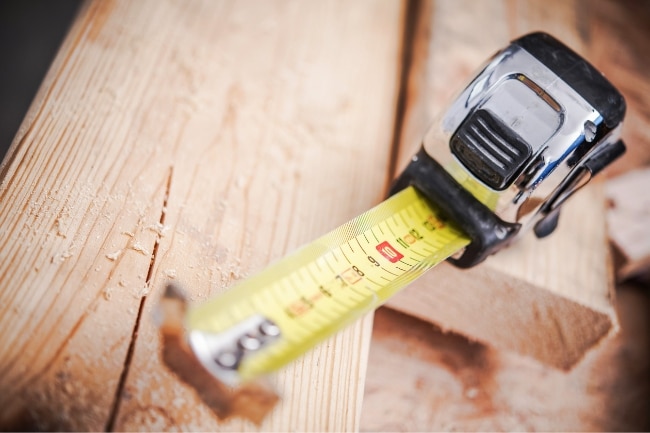 close up of measuring tape on a wooden board